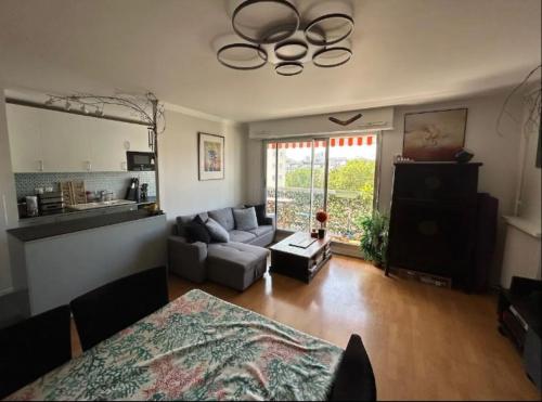 un salon avec un canapé et une table dans l'établissement Appartement familial 3ch balcon Tour Eiffel 15min, à Paris