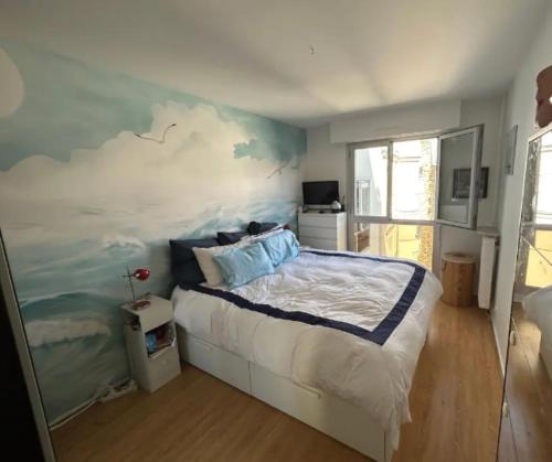 une chambre avec un grand lit avec un tableau au mur dans l'établissement Appartement familial 3ch balcon Tour Eiffel 15min, à Paris
