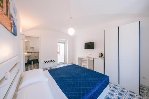 a bedroom with a blue bed in a white room at A Gradillo holiday rooms in Ravello