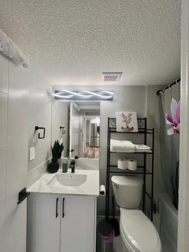 a bathroom with a white toilet and a sink at Adorable Private Suite in Seton SE, Calgary in Calgary