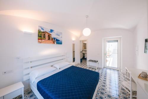 a bedroom with a blue bed in a white room at A Gradillo holiday rooms in Ravello