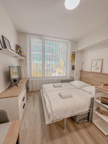a bedroom with a large bed and a desk at My Mozartova in Prague