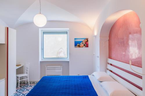 a bedroom with a blue bed and a window at A Gradillo holiday rooms in Ravello