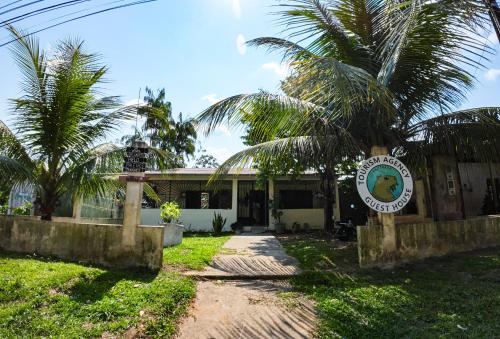 a building with a palm tree in front of it at Capibara guest house in Leticia
