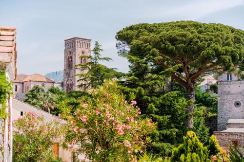a tree in front of a building with a clock tower at A Gradillo holiday rooms in Ravello