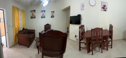 Una sala de estar con una mesa y sillas y un televisor. en Apartamentos swiss, en Sosúa
