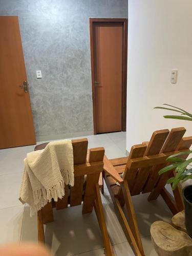 a group of wooden chairs in a room with a door at Apartamento no Centro in Palmas
