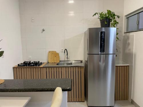 a kitchen with a stainless steel refrigerator and a sink at Apartamento no Centro in Palmas