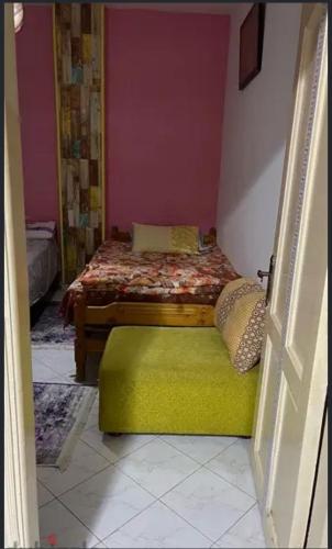 - une chambre avec un lit et un pouf vert dans l'établissement شاليه للإيجار في راس سدر جولدن بيتش2, à Raʼs Matarma