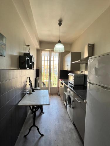 une cuisine avec une table et un réfrigérateur dans l'établissement Studio style vintage à Nice, à Nice