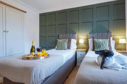 a bedroom with two beds with a tray of food and drinks at Stylish Apartment - Central Location - Free Parking, Self-Check-In, Fast Wifi and Smart TV by Yoko Property in Northampton