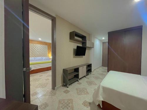 a bedroom with a bed and a tv and a mirror at Hotel Prado 72 INN in Barranquilla