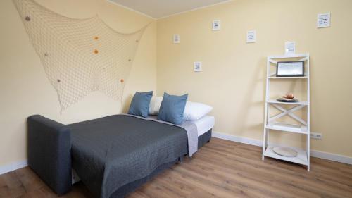 a bedroom with a bed with blue pillows and a shelf at Captains Quarters 5 in Dahme in Dahme