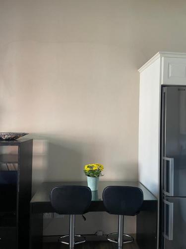a kitchen with a table with two chairs and a refrigerator at Three Flags in Pietermaritzburg