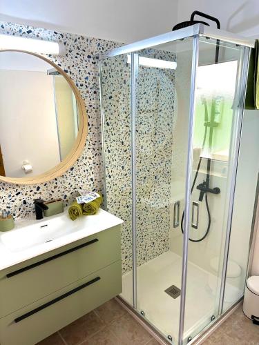Un baño con ducha con lavabo y espejo. en Bohemian good vibes only, en Costa Calma