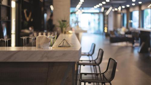 a counter in a restaurant with chairs and a table at Holiday Inn - the niu, Coin Frankfurt Ostend by IHG in Frankfurt/Main