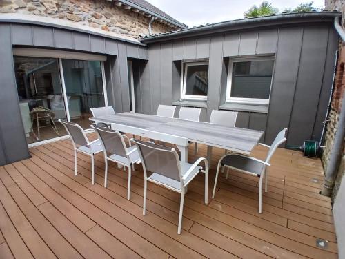 a wooden table and chairs on a deck at Appartement en centre-ville - Local vélos disponible in Mayenne