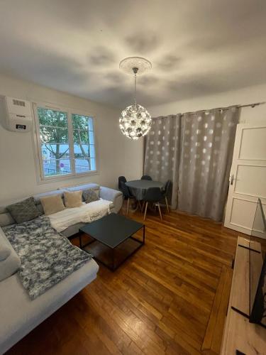 un salon avec un canapé et une table dans l'établissement Appartement aux portes de Paris, à Alfortville