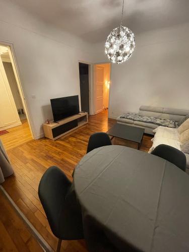 un salon avec une table et un canapé dans l'établissement Appartement aux portes de Paris, à Alfortville