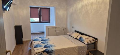 a small bedroom with a bed and a window at Apartament Roman in Roman
