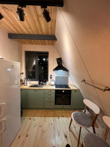 una cucina con mobili verdi e una stufa forno superiore di Bakhmaro A-frame a Chʼkhakoura