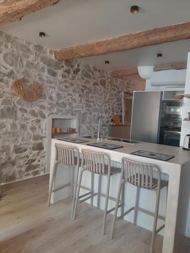 une cuisine avec un comptoir blanc et des tabourets dans l'établissement Atelier d'artiste, au Muy