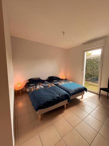 une chambre avec un lit et une grande fenêtre dans l'établissement Élégance Moderne centre, neuf avec jardin, à Gujan-Mestras
