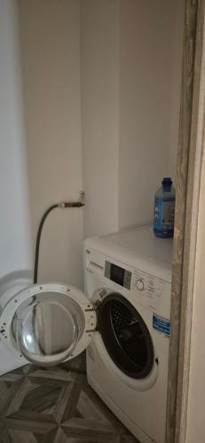 a washing machine in a small room with aiger at Apartament Roman in Roman