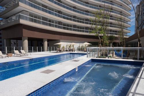 a swimming pool in front of a building at Book Santos - Unlimited 2611 - Studio conceito com Vista Mar in Santos