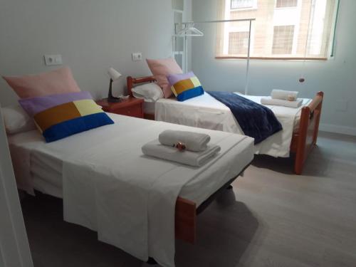 a bedroom with two beds with towels and a window at Akelarre in Bilbao