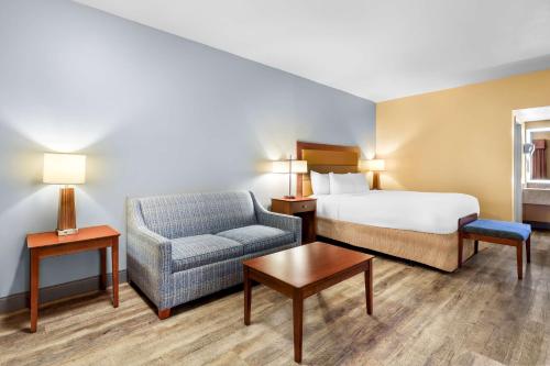 a hotel room with a bed and a chair at Sure Stay Plus by Best Western Twentynine Palms Joshua Tree in Twentynine Palms