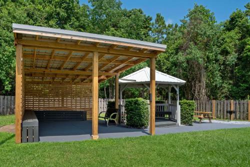 a wooden pavilion with a bench in a yard at Best Western Plus Blue Angel Inn in Pensacola