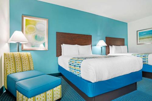 a hotel room with two beds and a chair at Best Western Plus Blue Angel Inn in Pensacola