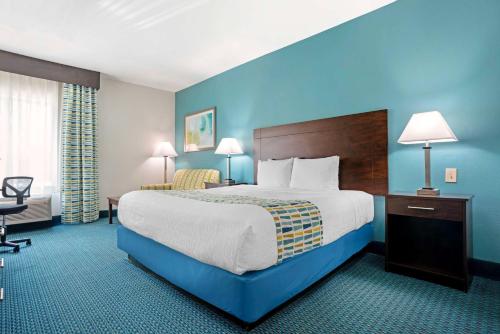 a hotel room with a large bed with blue walls at Best Western Plus Blue Angel Inn in Pensacola