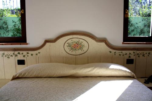 a bed in a bedroom with two windows at B&B Podere Montese in Villafranca in Lunigiana