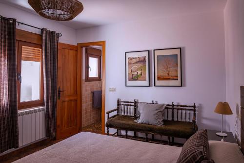 a bedroom with a bench and a window and a door at La casa de la Fuente Vieja in Villanueva de los Infantes