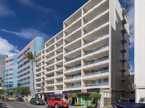an exterior view of a building with a parking lot at Regency on Beachwalk Waikiki by OUTRIGGER in Honolulu