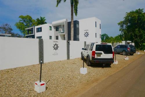 a white truck parked in front of a building at LEVEL suites premium in Sosúa