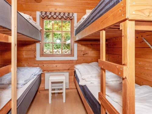 two bunk beds in a cabin with a window at 6 person holiday home in Roslev-By Traum in Roslev
