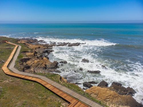 an aerial view of the ocean with a path on the rocks at Windrush Inn - Cambria in Cambria