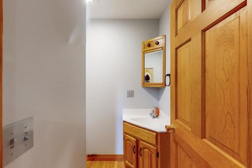 Un baño con lavabo y puerta de madera. en Chillaxin, en McHenry