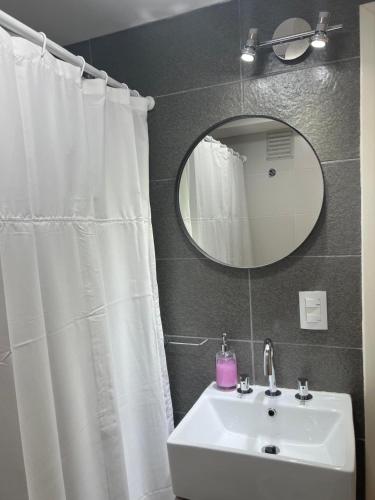 a bathroom with a white sink and a mirror at Departamento Céntrico Álamos in Santa Rosa