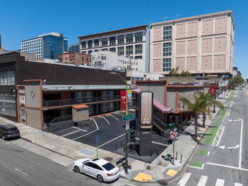 an intersection with a white car on a city street at Alexis Park San Francisco in San Francisco