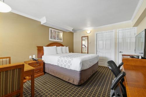 a hotel room with a bed and a desk and a television at Alexis Park San Francisco in San Francisco