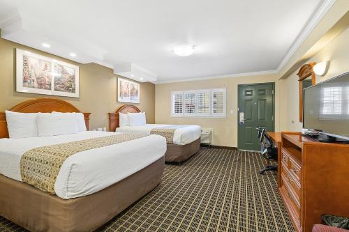 a hotel room with two beds and a flat screen tv at Alexis Park San Francisco in San Francisco