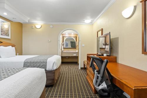 a hotel room with two beds and a desk at Alexis Park San Francisco in San Francisco
