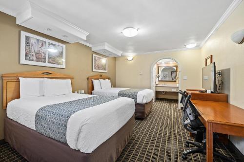 a hotel room with two beds and a desk at Alexis Park San Francisco in San Francisco
