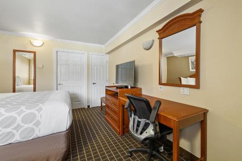 a hotel room with a bed and a desk with a chair at Alexis Park San Francisco in San Francisco