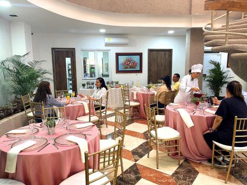 a group of people sitting at tables in a restaurant at Hotel Prado 72 INN in Barranquilla