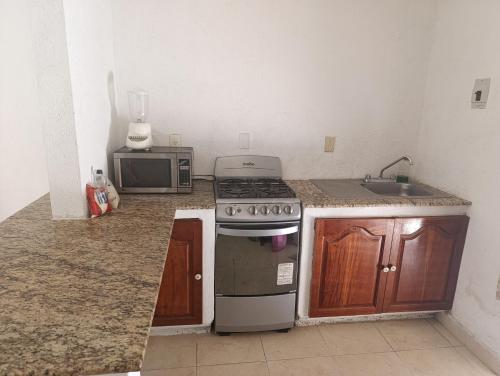 une cuisine avec une cuisinière et un micro-ondes dans l'établissement Casa Victor Manuel, à La Sabana